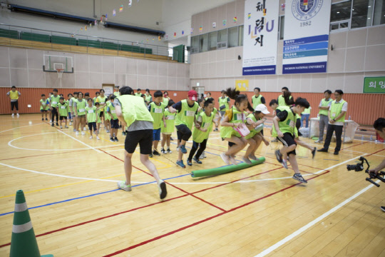지난 17일 인천대 실내체육관에서 열린 원앤원 명랑운동회에서 포스코건설 직원과 인천 지역아동센터 어린이들이 파도타기를 하고 있다.<포스코건설 제공>